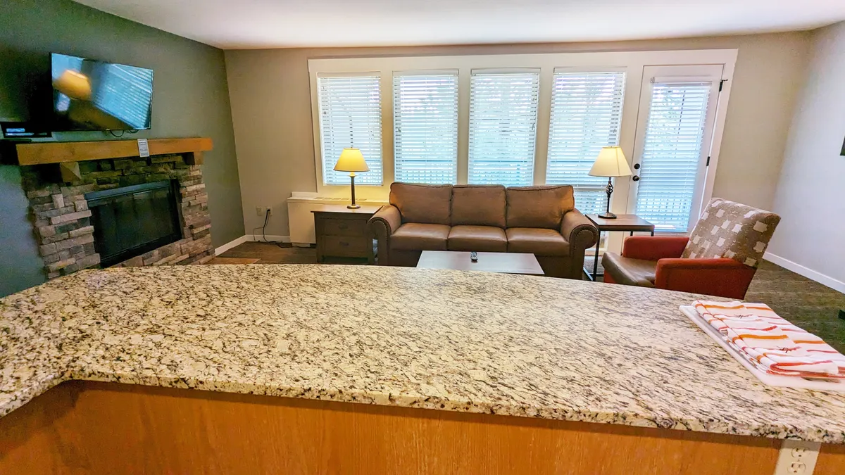 A cozy living area with a fireplace, comfortable sofa, granite countertop, and a window bringing in soft natural light. The scene invites relaxation and connection, echoing the section's emphasis on unwinding after outdoor adventures.